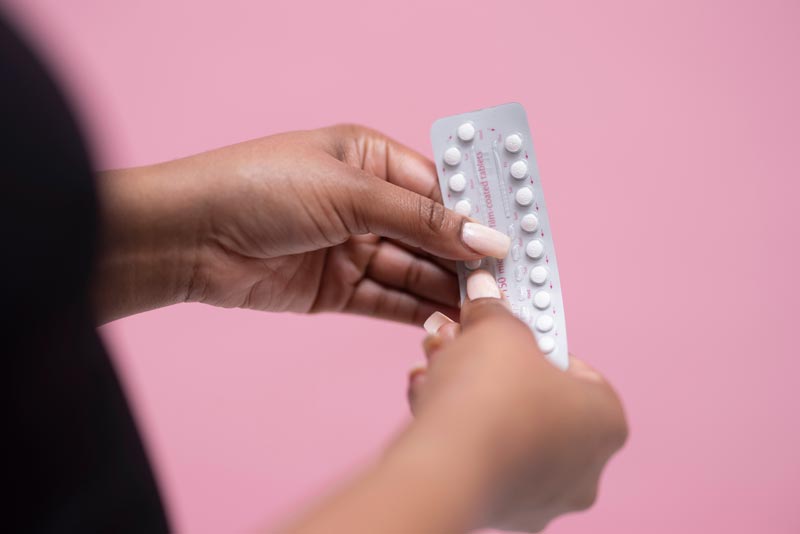 Woman holding oral contraceptive pills