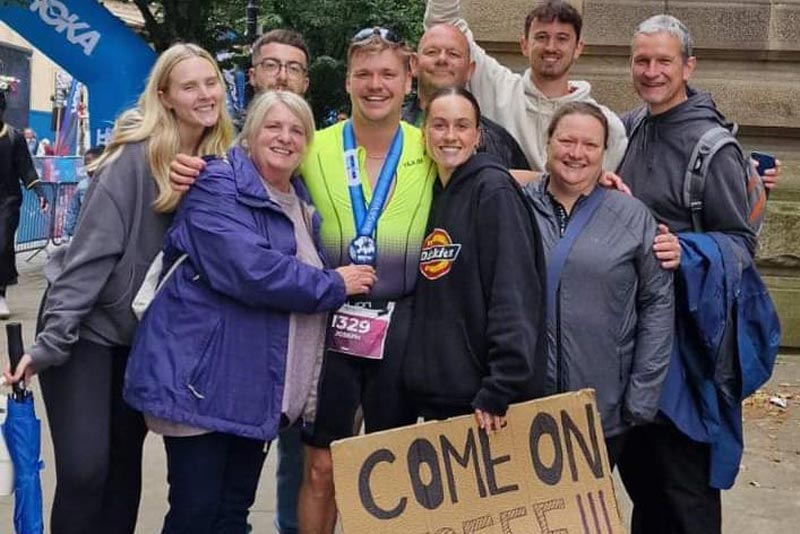 Joe Hartshorne with his medal celebrating with his family